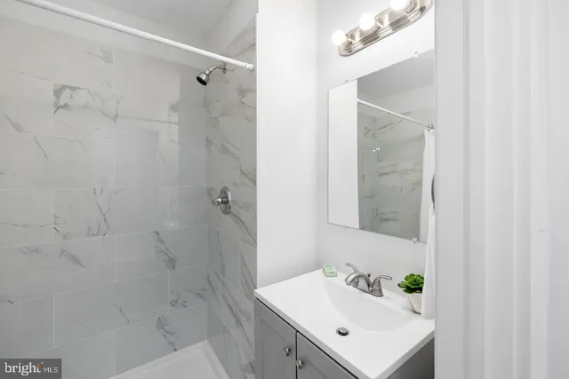 a bathroom with a sink a shower and a mirror