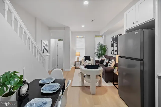 a view of a dining room with furniture a rug and wooden floor