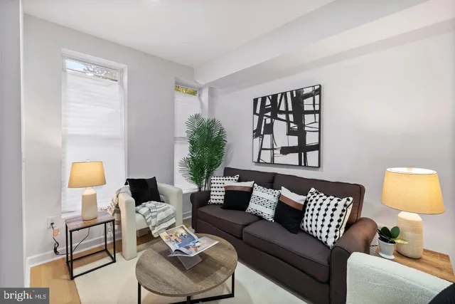 a living room with furniture and a lamp with wooden floor