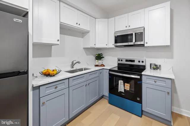 a kitchen with stainless steel appliances white cabinets sink and a stove