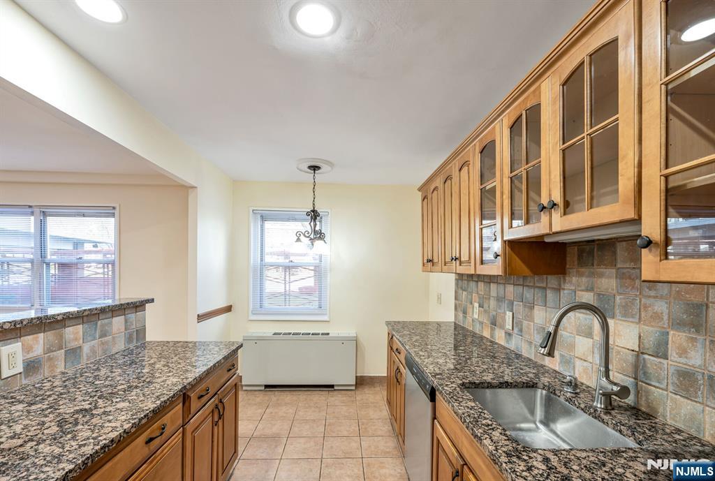 280 Prospect Avenue, Unit 1B Hackensack, NJ 07601 - Photo 13 of 36 a kitchen with stainless steel appliances granite countertop a sink a stove and a wooden cabinets