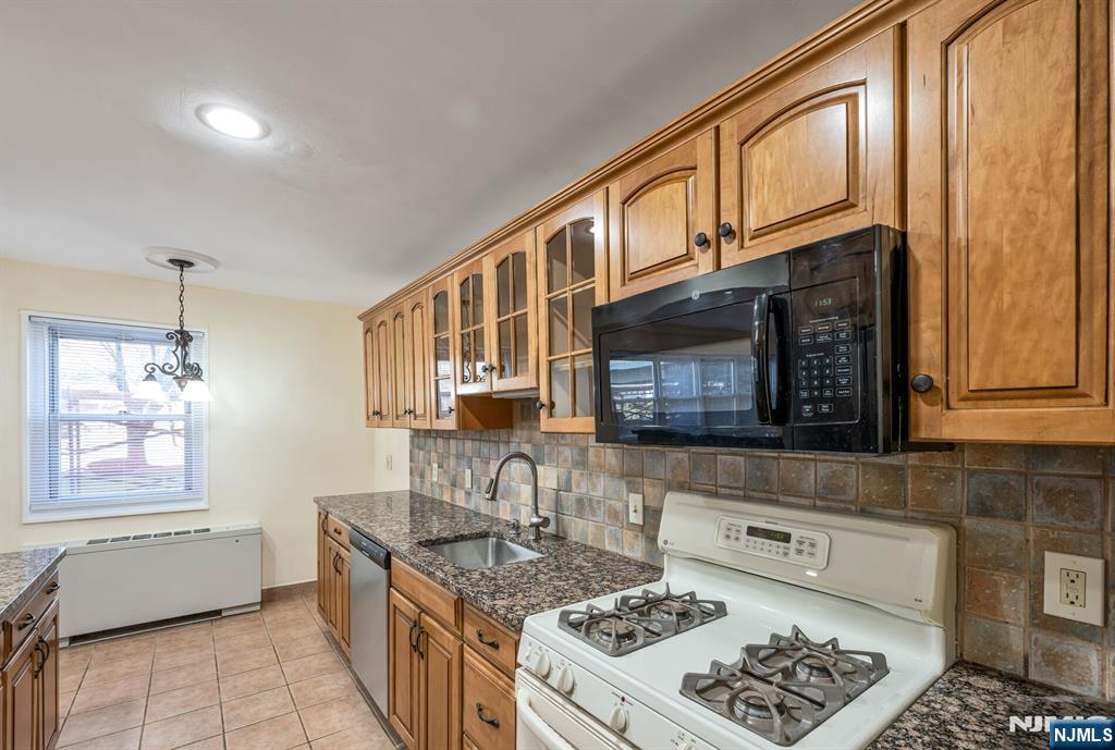 280 Prospect Avenue, Unit 1B Hackensack, NJ 07601 - Photo 15 of 36 a kitchen with stainless steel appliances granite countertop a stove a sink and a microwave