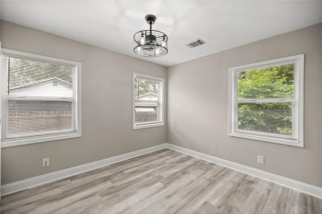 a view of a room with wooden floor and a window
