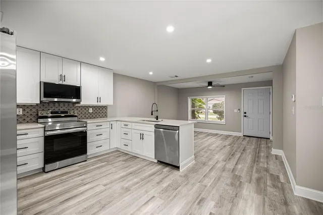a kitchen with stove cabinets and wooden floor