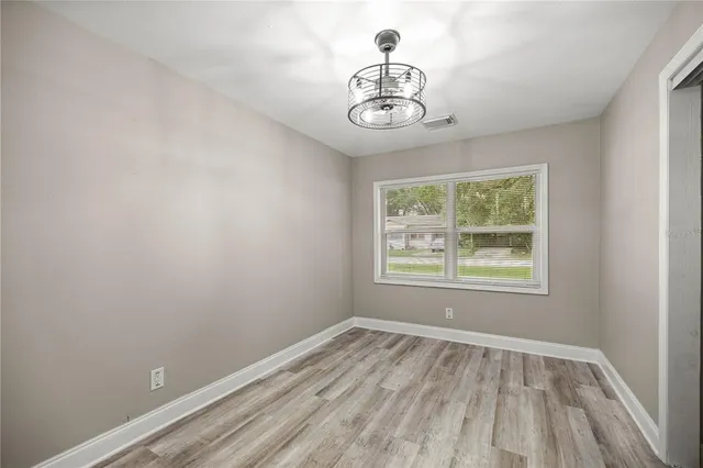 a view of empty room with window and chandelier