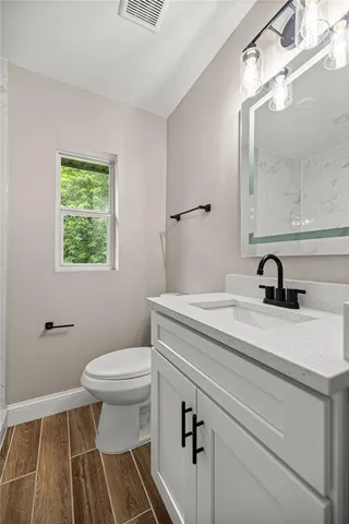 a bathroom with a sink a toilet and a mirror
