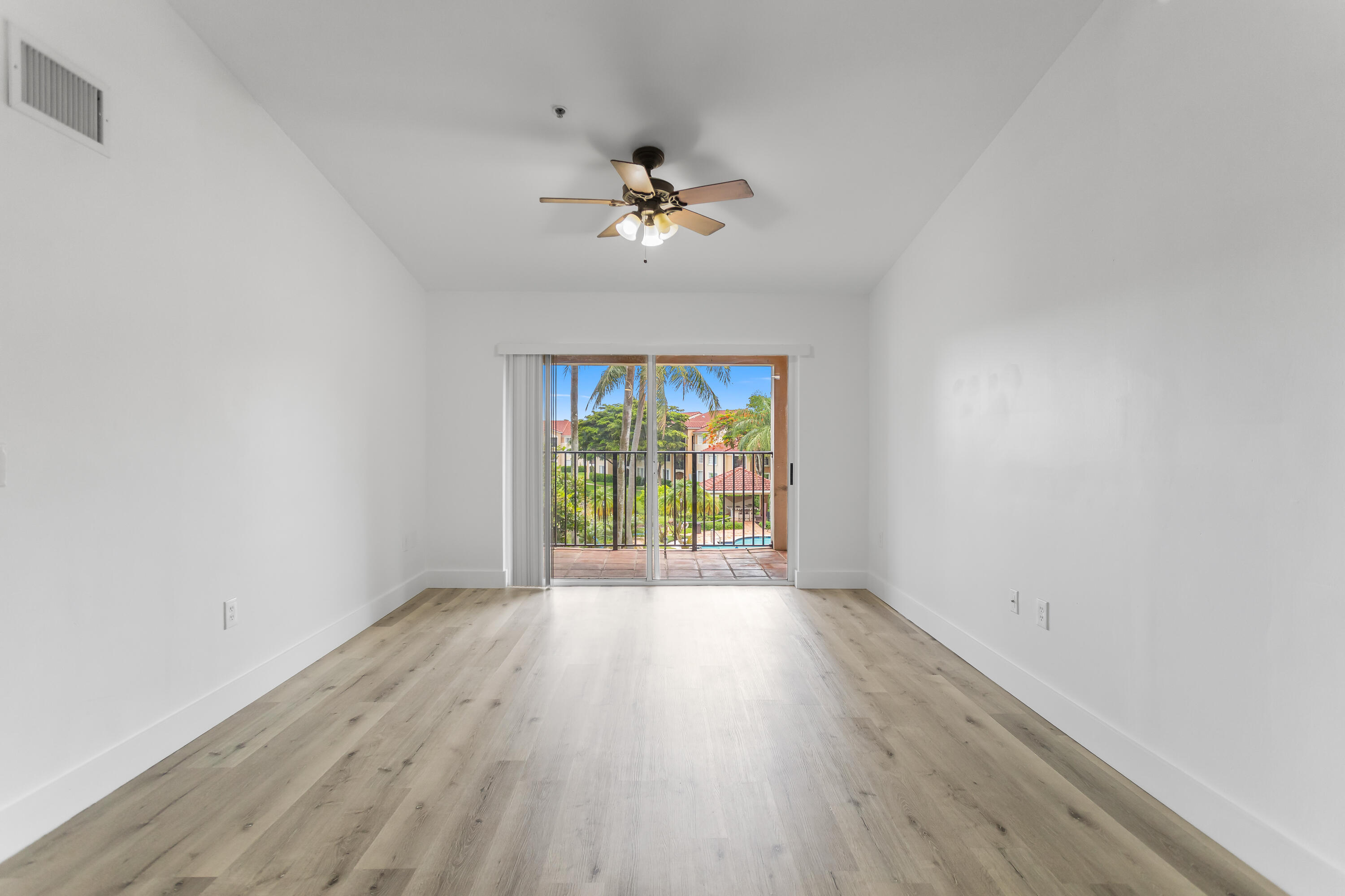 2113 Renaissance Boulevard, Unit 306 Miramar, FL 33025 - Photo 15 of 59 an empty room with wooden floor fan and windows