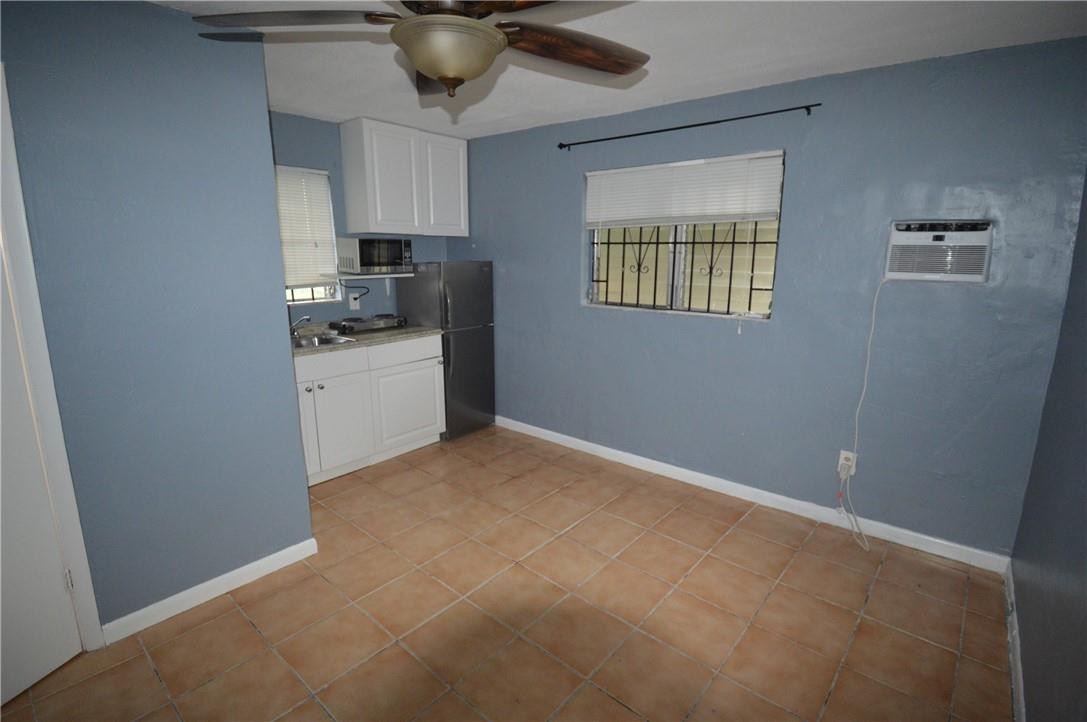 807 Phippen Waiters Road, Unit 1 Dania Beach, FL 33004 - Photo 5 of 6 a kitchen with kitchen island a sink a stove and a refrigerator