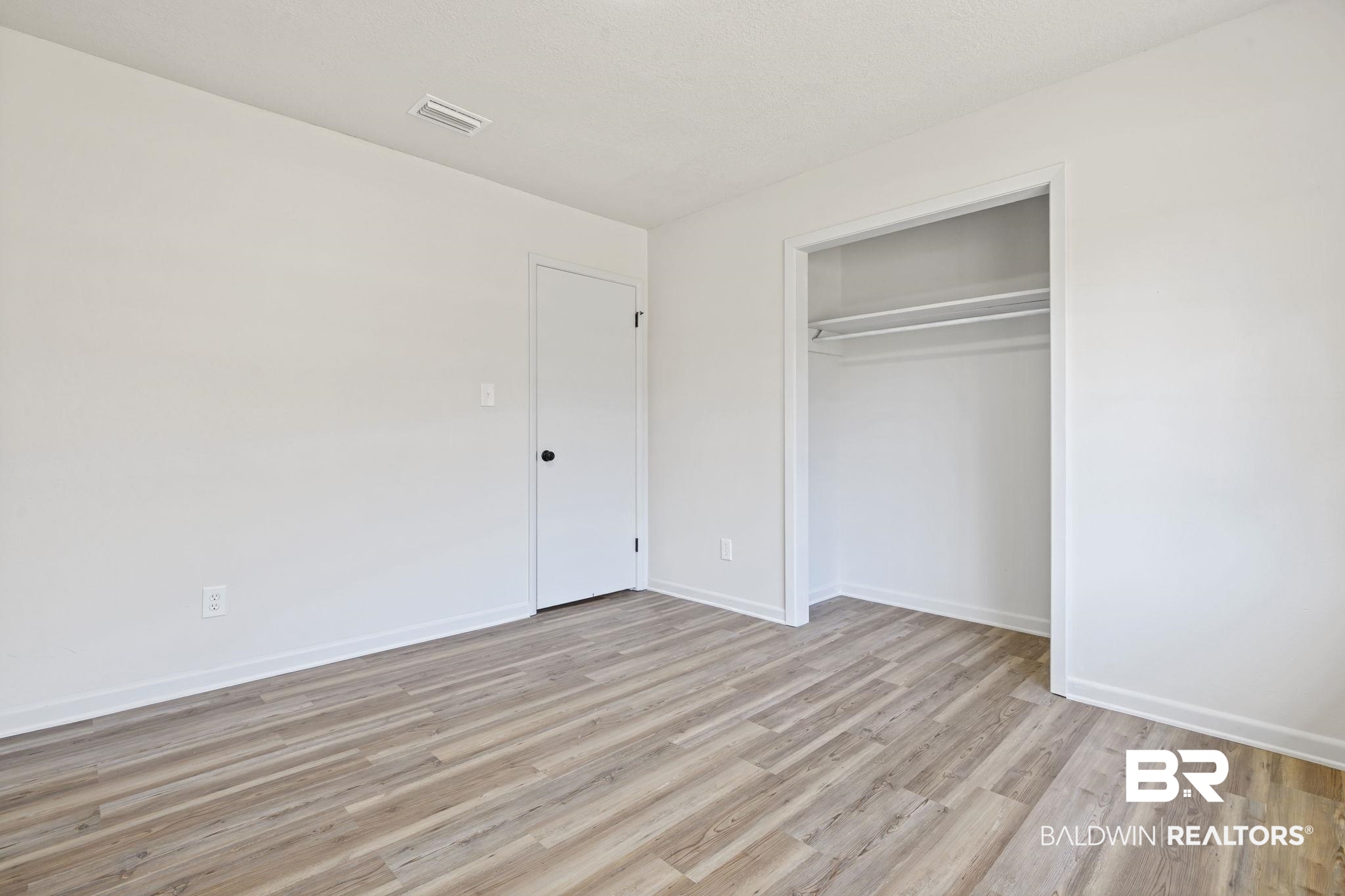 910 Moran Street Bay Minette, AL 36507 - Photo 12 of 20 Unfurnished bedroom featuring light wood-type flooring and a closet