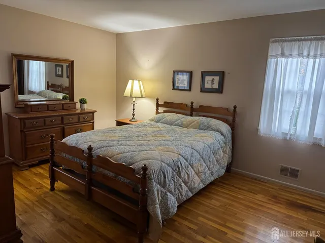 a bedroom with a bed and wooden floor