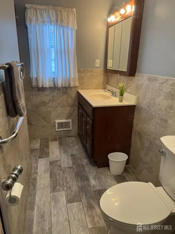 a bathroom with a toilet a sink and mirror