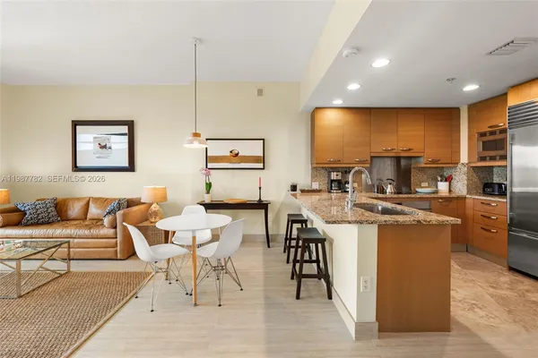 a living room with stainless steel appliances kitchen island granite countertop furniture and a large window