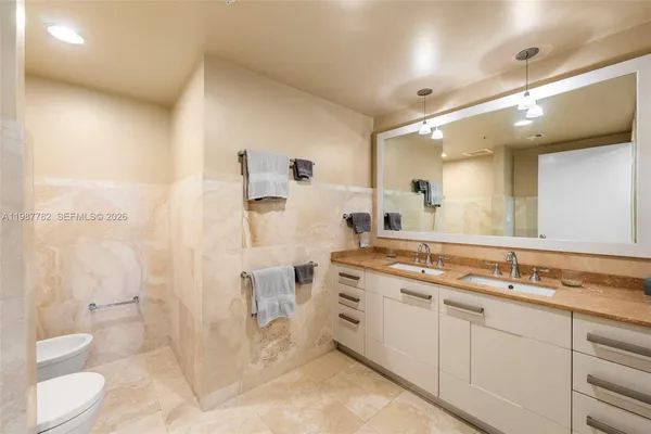 a spacious bathroom with a granite countertop sink mirror and a toilet