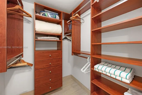 a view of walk in closet with clothes and shoes