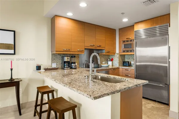 a kitchen with kitchen island a counter top space appliances and a sink