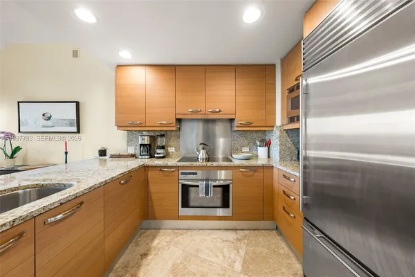 a kitchen with stainless steel appliances granite countertop a sink stove and refrigerator