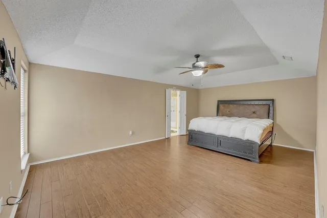 a bedroom with a bed and a ceiling fan