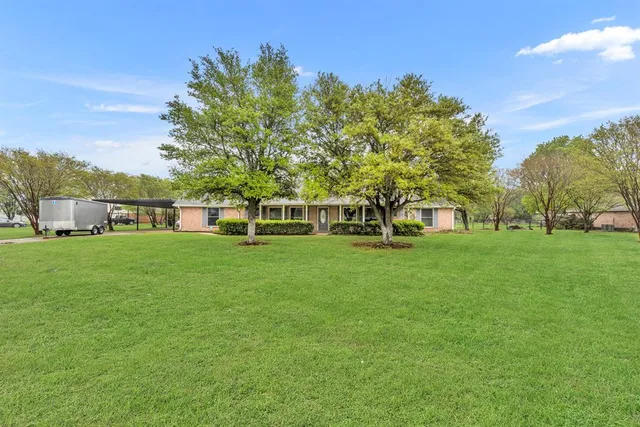 a view of house with garden space and trees