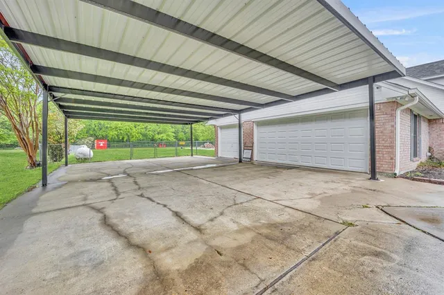 a view of garage with a car parked in front of it