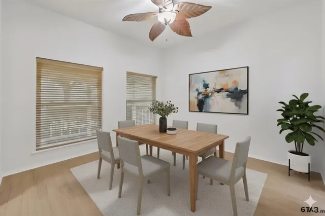 a dining room with furniture potted plants and wooden floor