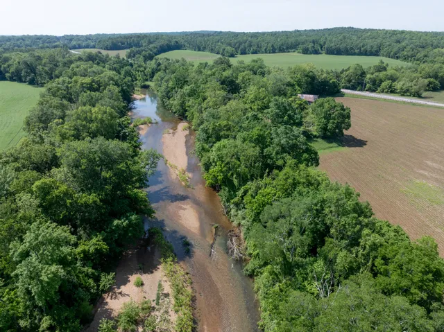an aerial view of a house with a yard and lake view