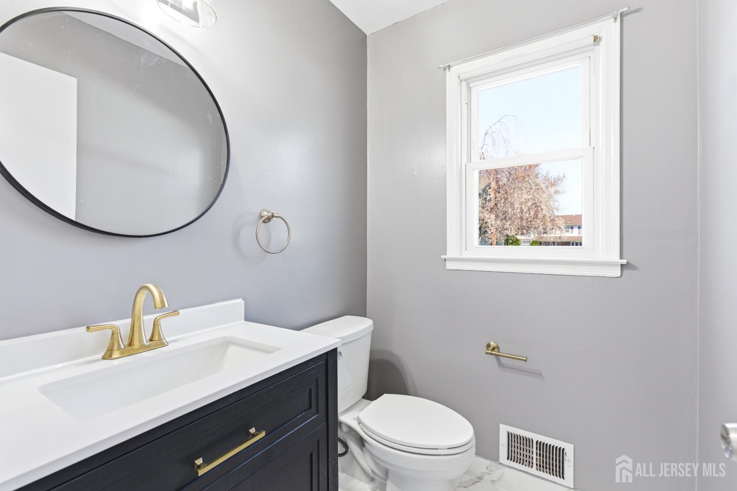 7 Oberlin Court Edison, NJ 08820 - Photo 21 of 45 a bathroom with a toilet a sink a mirror and vanity