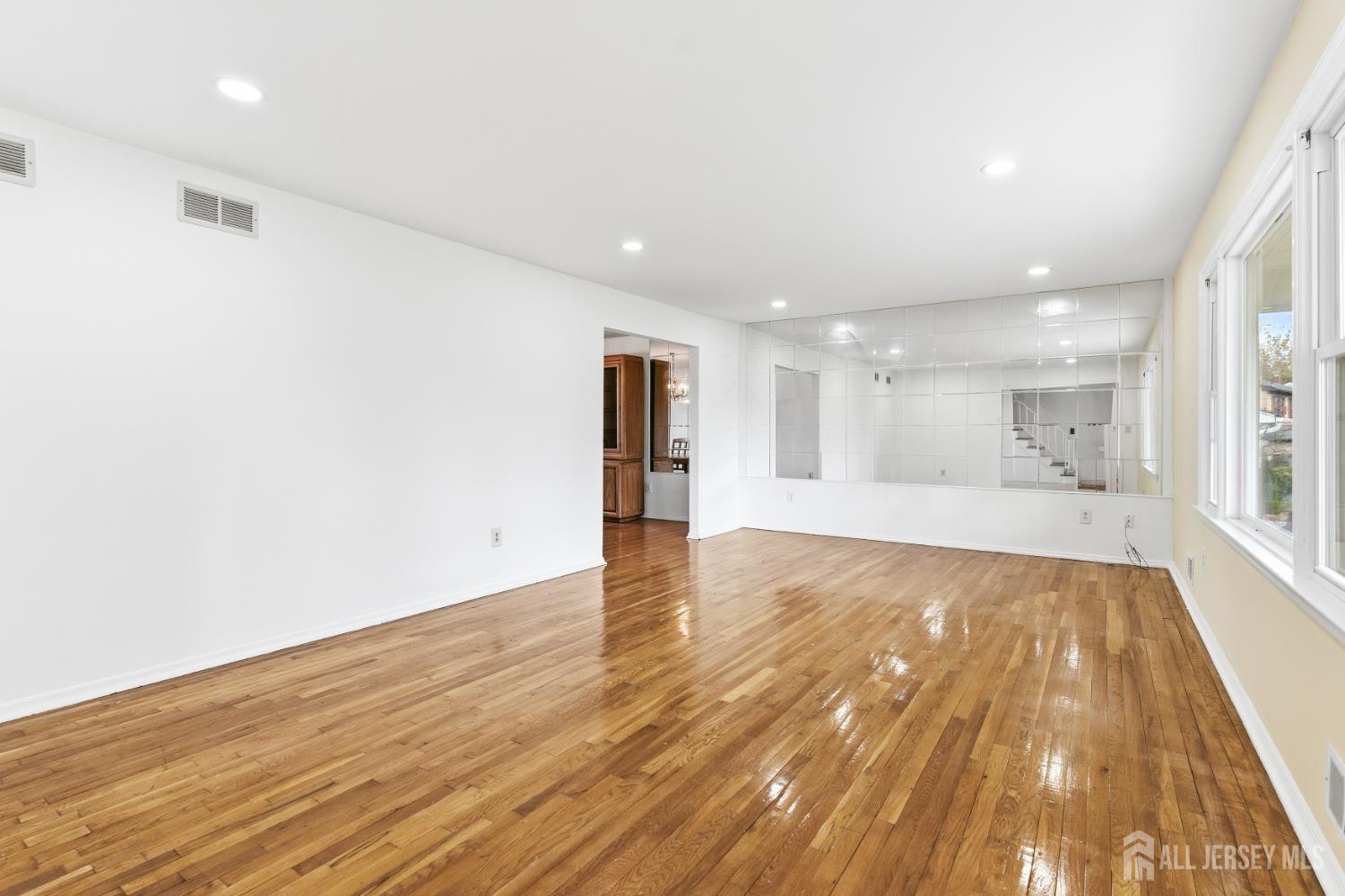 7 Oberlin Court Edison, NJ 08820 - Photo 6 of 45 a view of an empty room with wooden floor and a window