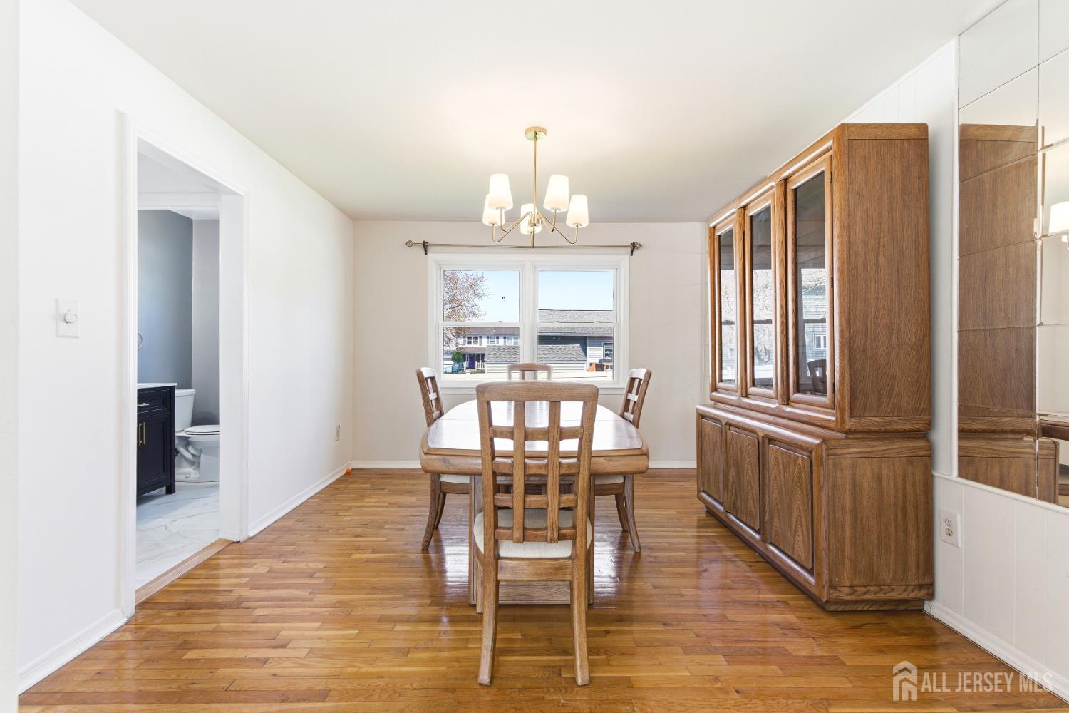 7 Oberlin Court Edison, NJ 08820 - Photo 8 of 45 a dining room with wooden floor a chandelier a wooden table and chairs