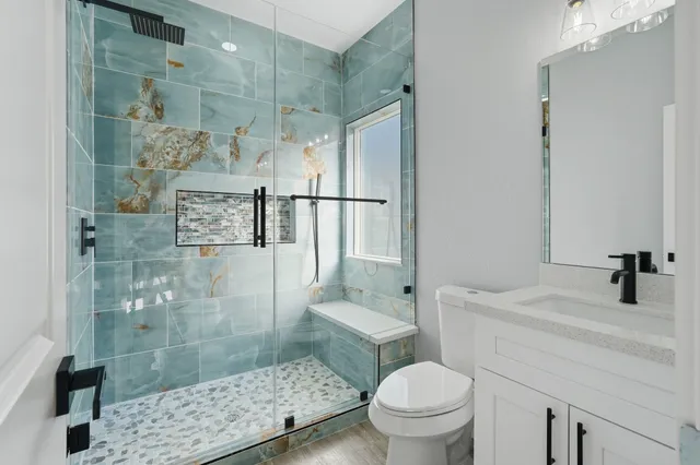 a bathroom with a sink a toilet and shower