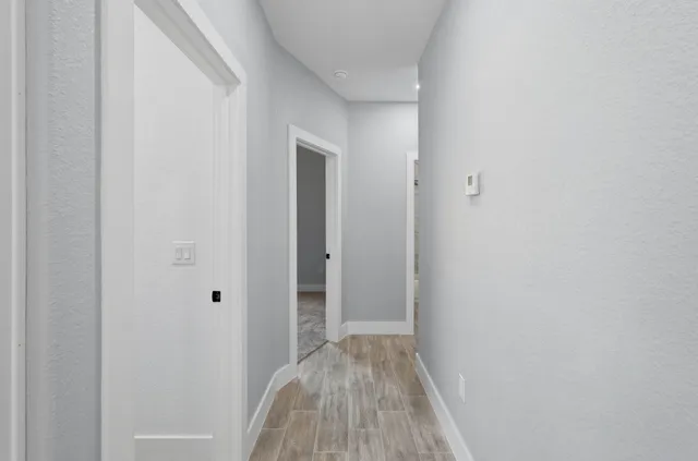 a view of a hallway with wooden floor