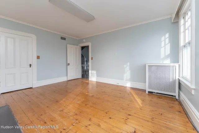 an empty room with windows and closet