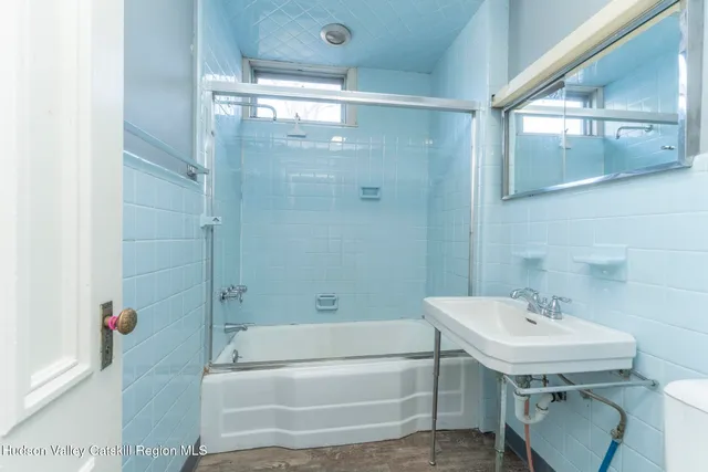 a kitchen with a stove a sink and wooden floor