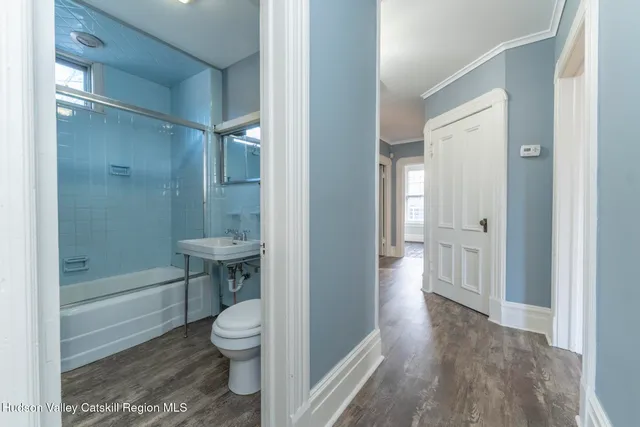 a kitchen with kitchen island wooden floors appliances and cabinets