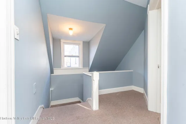 an empty room with windows and ceiling fan