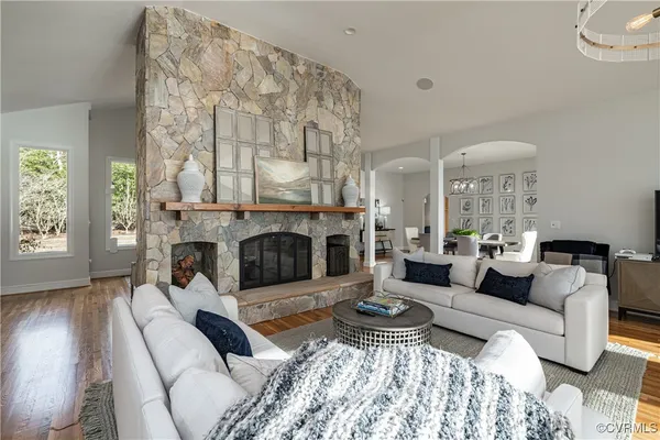 a living room with furniture a chandelier and a flat screen tv