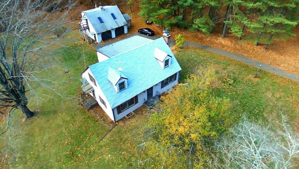 an aerial view of a house with a yard basket ball court and outdoor seating