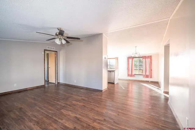 a kitchen with kitchen island granite countertop a stove a sink a refrigerator and white cabinets with wooden floor