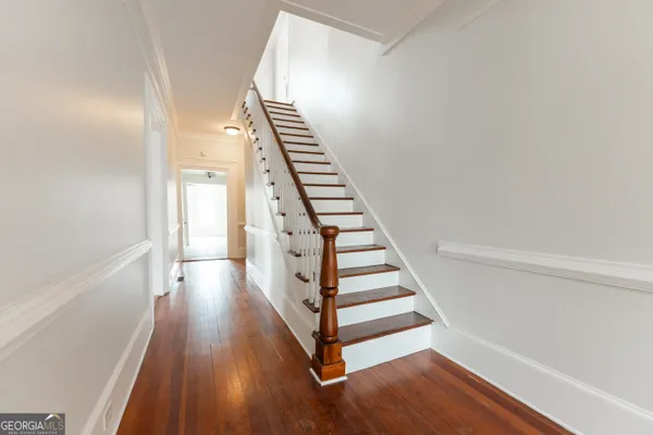 an empty room with wooden floor and a ceiling fan