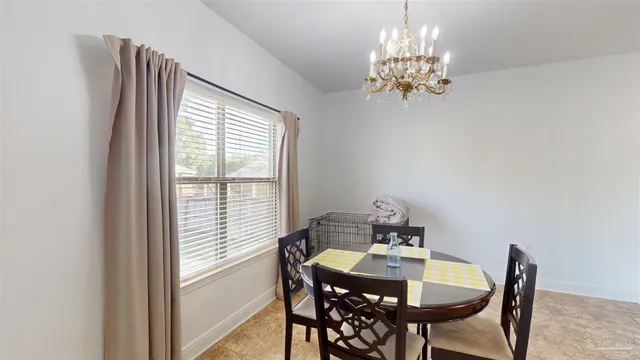 a view of a dining room with furniture a chandelier and window
