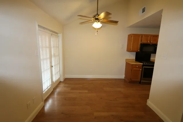 an empty room with windows and fan