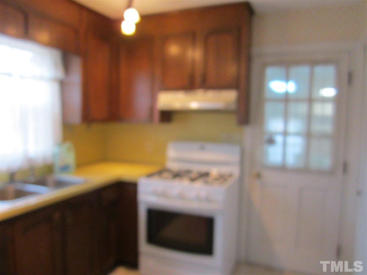 1401 Falls Church Road Raleigh, NC 27609 - Photo 4 of 11 a kitchen with a sink and a stove