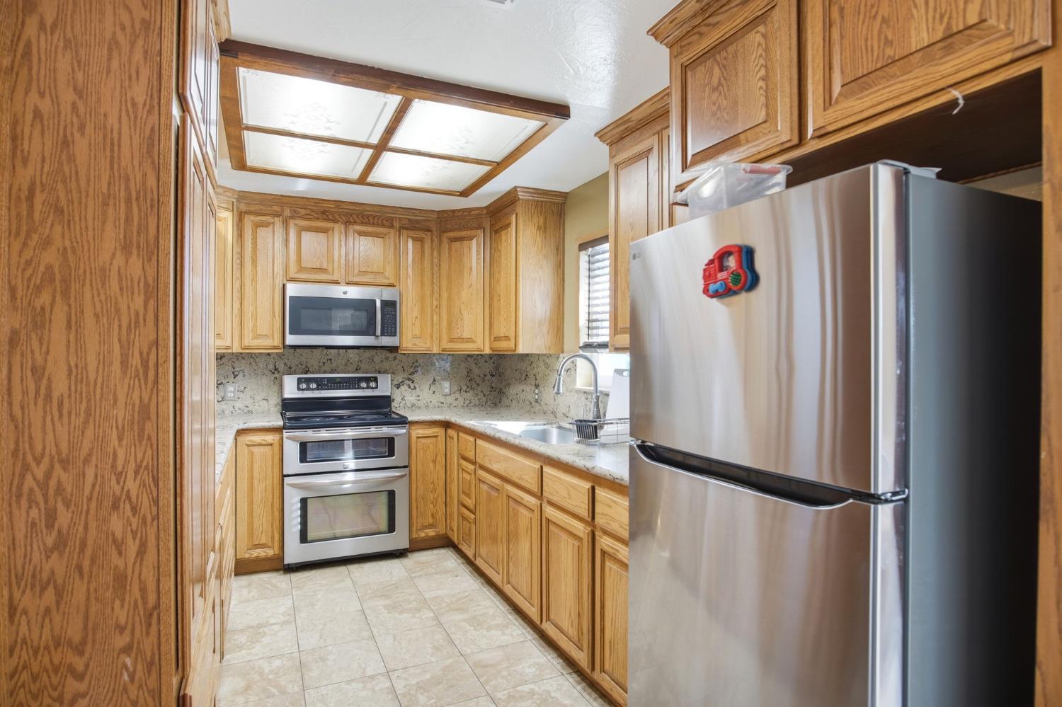2406 South Walnut Road Turlock, CA 95380 - Photo 11 of 42 a kitchen with stainless steel appliances a refrigerator sink and microwave