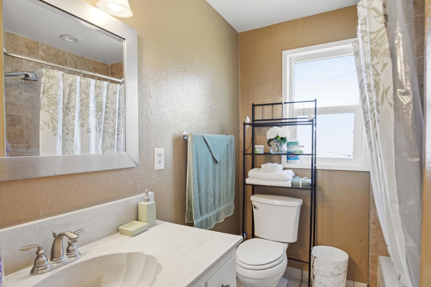 2406 South Walnut Road Turlock, CA 95380 - Photo 15 of 42 a bathroom with a sink toilet and shower