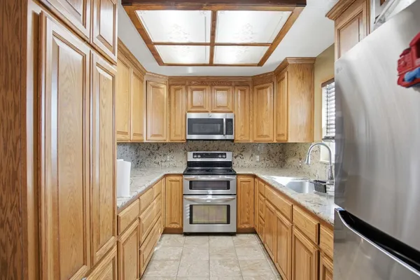 a kitchen with stainless steel appliances a dining table and chairs