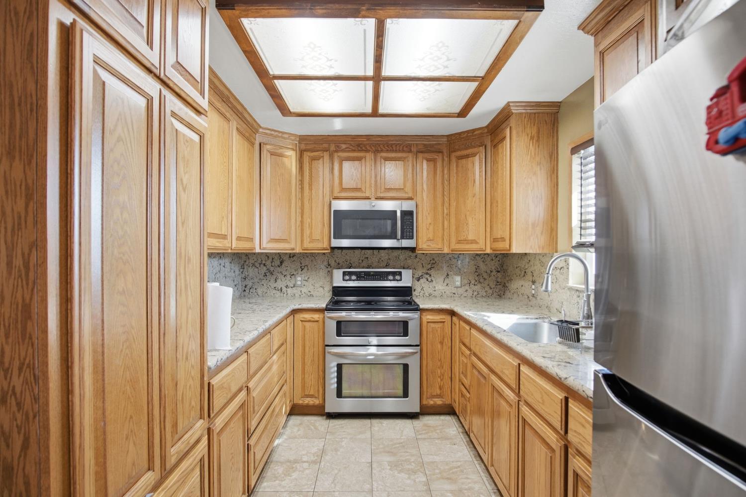 2406 South Walnut Road Turlock, CA 95380 - Photo 10 of 42 a kitchen with stainless steel appliances granite countertop a stove and a refrigerator