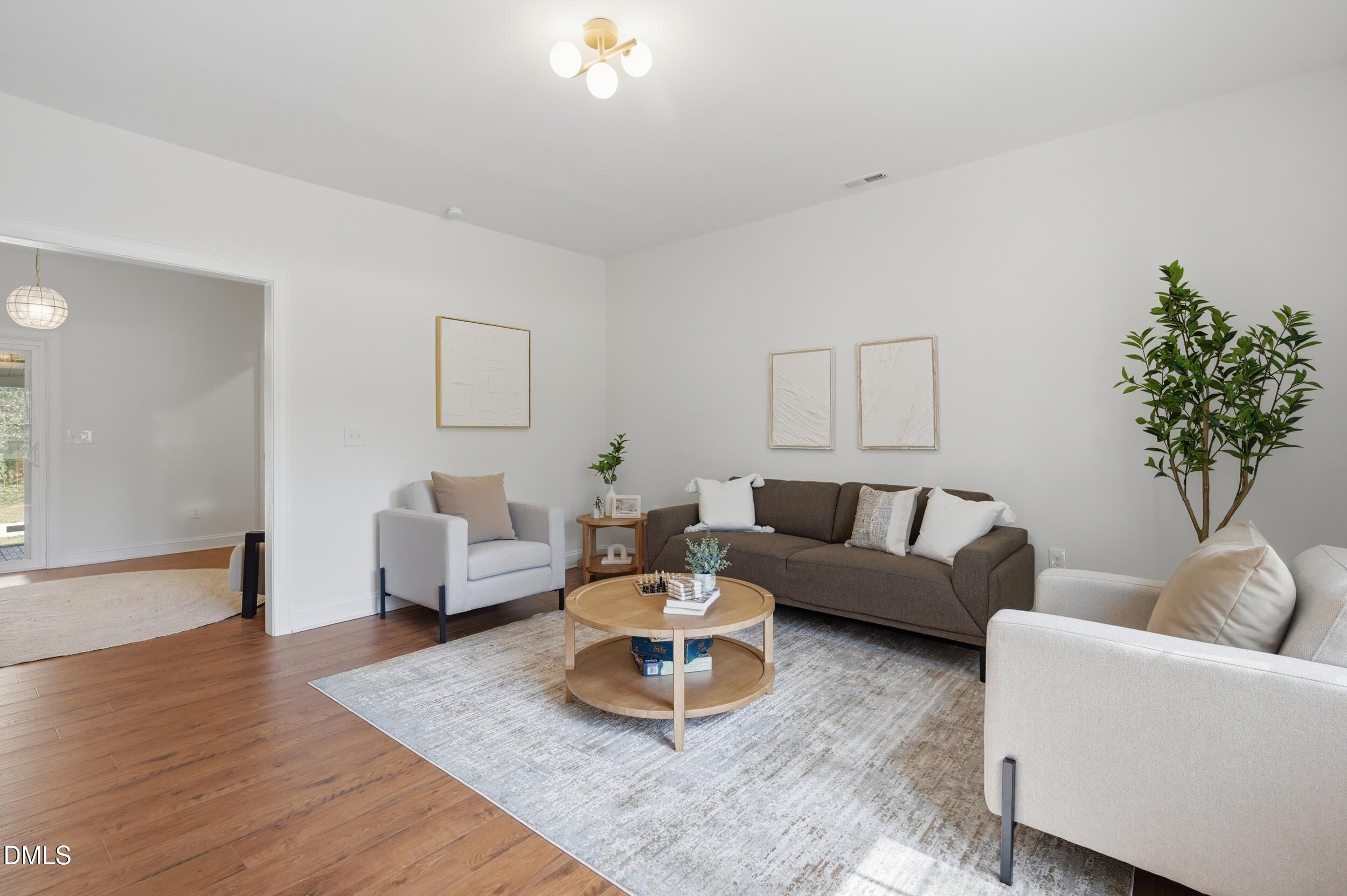 2301 Milburnie Road Raleigh, NC 27610 - Photo 7 of 23 a living room with furniture and a potted plant