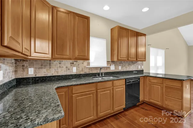 a kitchen with stainless steel appliances granite countertop wooden cabinets a sink and dishwasher