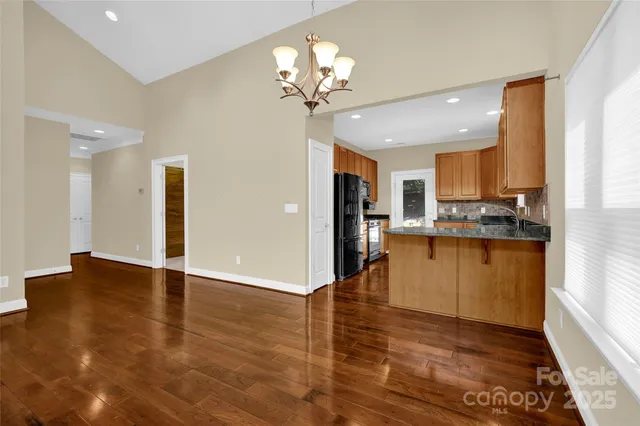a view of a kitchen with kitchen island a sink stainless steel appliances and cabinets