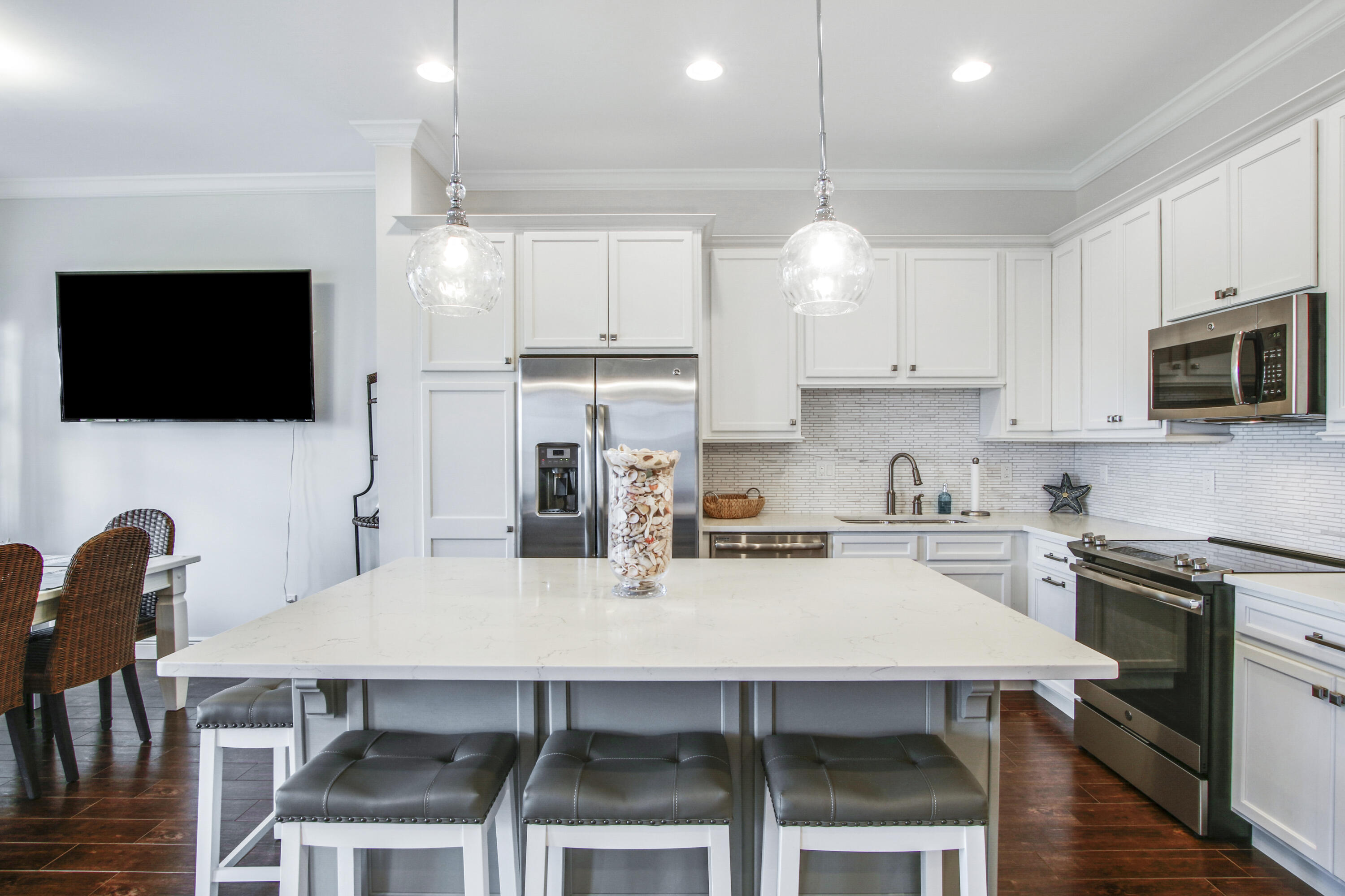132 Ocean Breeze Drive Juno Beach, FL 33408 - Photo 9 of 33 a kitchen with granite countertop a table chairs microwave and cabinets