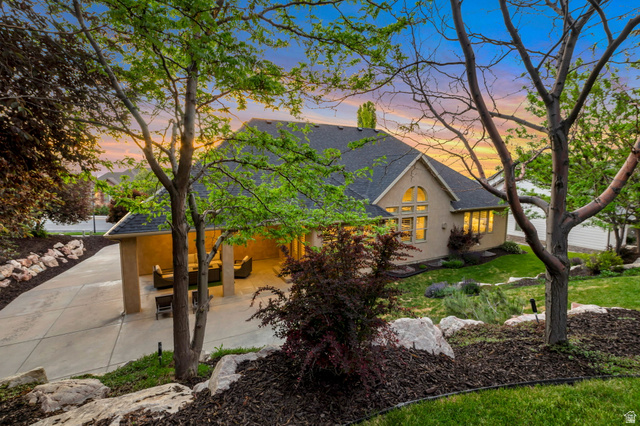 577 South Ridge Top Lane East North Salt Lake, UT 84054 - Photo 45 of 57 Private backyard retreat featuring mature trees, custom rockscaping, and a covered patio designed for year-round outdoor living.